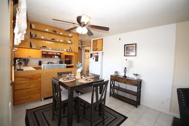 dining room featuring a ceiling fan, baseboards, and light tile patterned floors