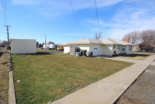 view of yard with an attached garage and driveway