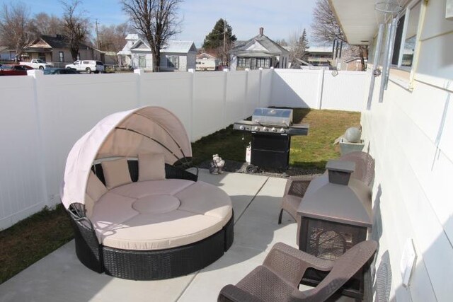 view of patio with a residential view, a fenced backyard, and a grill