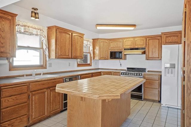 kitchen featuring white refrigerator with ice dispenser, stainless steel gas stove, a sink, black microwave, and under cabinet range hood