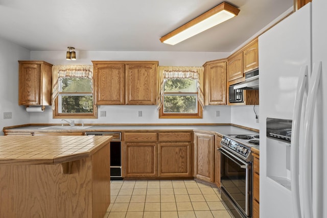 kitchen featuring tile counters, electric range, a sink, white fridge with ice dispenser, and dishwasher