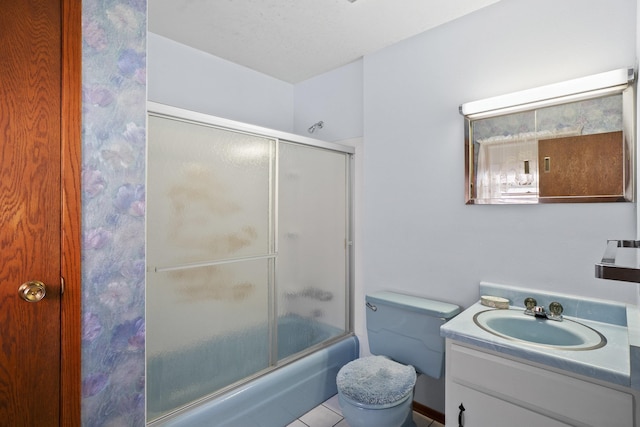 bathroom with toilet, combined bath / shower with glass door, and vanity