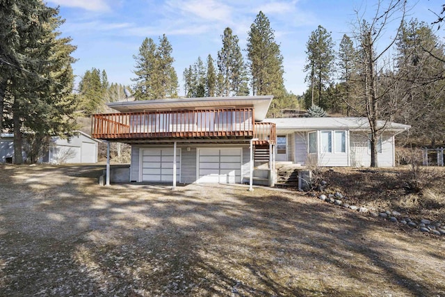 view of front facade featuring a garage, driveway, a deck, and stairway