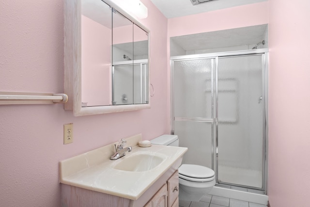 bathroom featuring visible vents, toilet, a stall shower, vanity, and tile patterned flooring