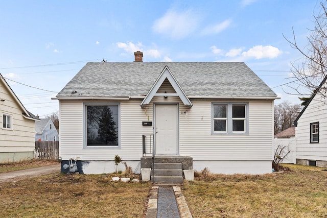 bungalow with a chimney, fence, and roof with shingles