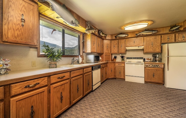 kitchen with white appliances, under cabinet range hood, and brown cabinets