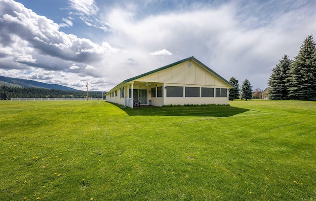 rear view of property featuring a yard and a mountain view