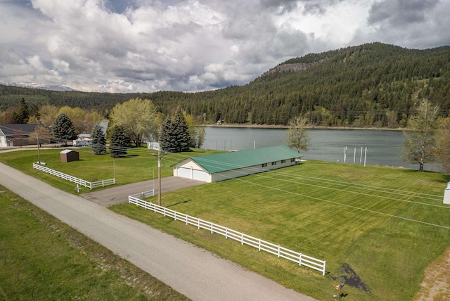 exterior space featuring fence, a wooded view, and a mountain view