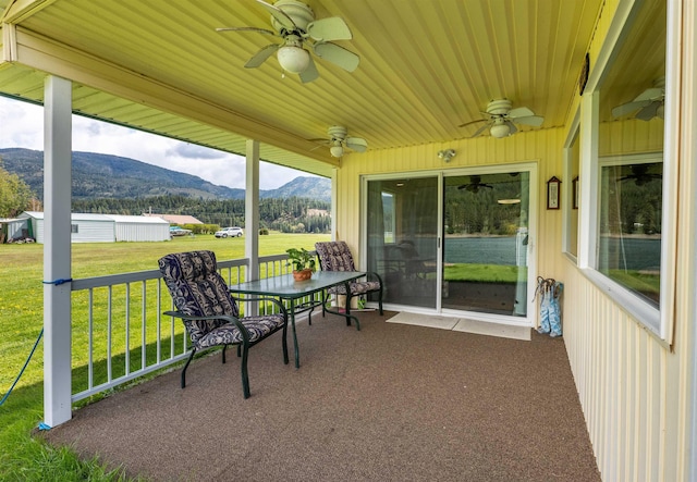 sunroom / solarium featuring a mountain view and ceiling fan