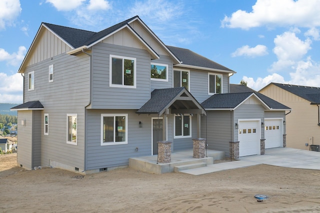 craftsman inspired home featuring a garage, driveway, a shingled roof, and board and batten siding