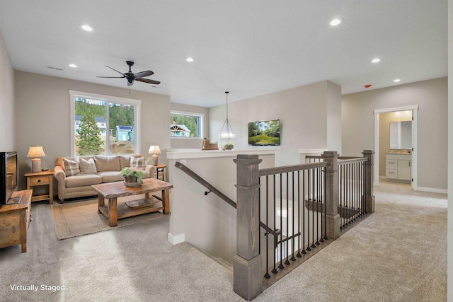 corridor with recessed lighting, baseboards, light colored carpet, and an upstairs landing