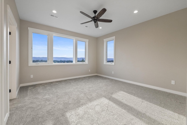 carpeted empty room with ceiling fan, visible vents, baseboards, and recessed lighting