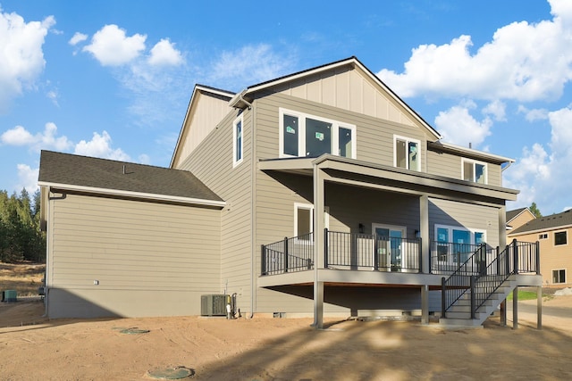 rear view of house featuring a deck, central AC, stairway, and board and batten siding