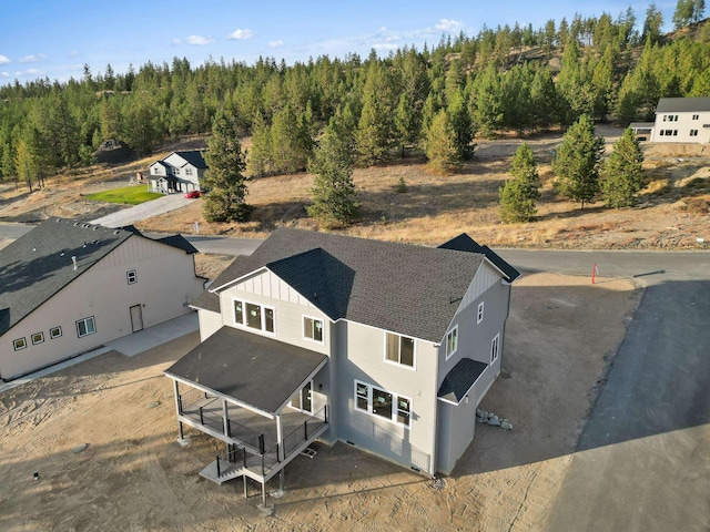 drone / aerial view featuring a wooded view