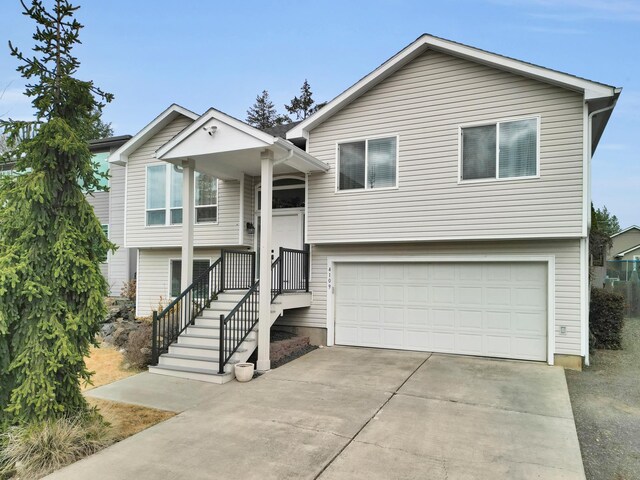 bi-level home featuring an attached garage and concrete driveway