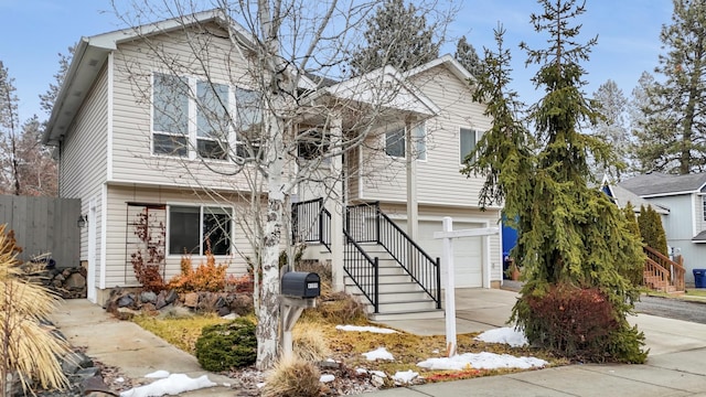 view of front of home with driveway, a garage, and fence