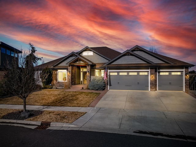 craftsman-style house featuring stone siding, concrete driveway, and an attached garage