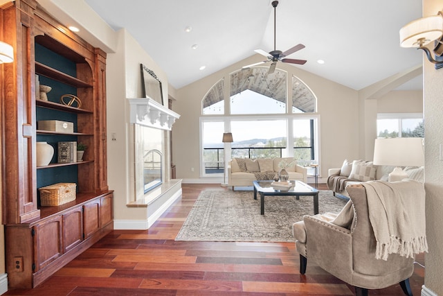 living area with baseboards, dark wood finished floors, a fireplace, high vaulted ceiling, and recessed lighting