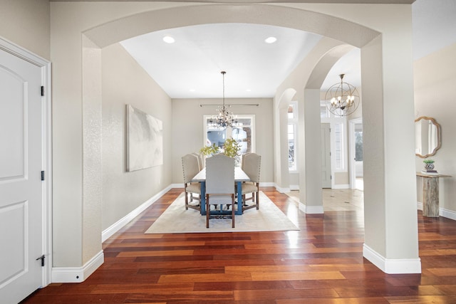 dining space with wood-type flooring, a chandelier, and baseboards