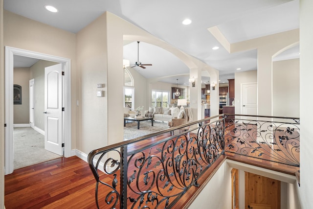 hall with arched walkways, baseboards, wood finished floors, and recessed lighting