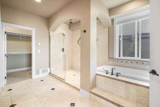 bathroom with a stall shower, visible vents, a garden tub, tile patterned flooring, and a walk in closet