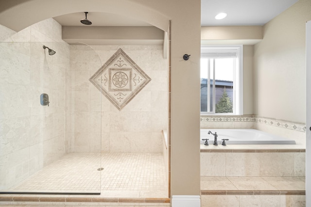 full bath with tiled shower and a garden tub