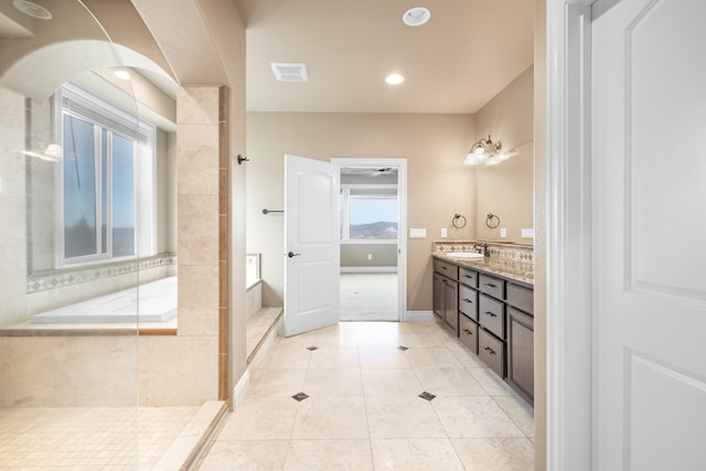 bathroom with a bathtub, double vanity, visible vents, a sink, and tile patterned floors