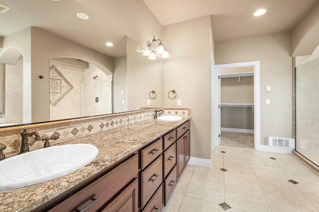 full bath featuring a stall shower, a sink, visible vents, and tile patterned floors