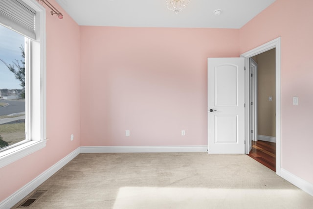 carpeted empty room with baseboards and visible vents