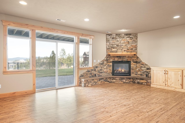 unfurnished living room with recessed lighting, visible vents, wood finished floors, and a fireplace