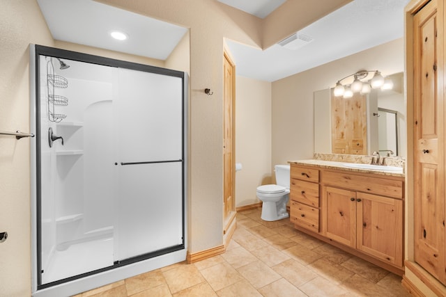 bathroom featuring vanity, toilet, baseboards, a shower stall, and visible vents