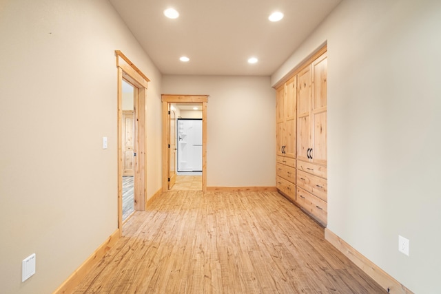 corridor featuring light wood-type flooring, baseboards, and recessed lighting