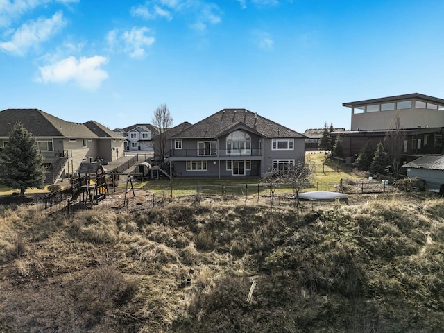 rear view of house featuring fence and a residential view