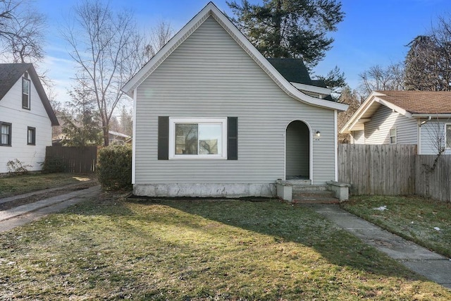 view of front of house featuring fence and a front lawn