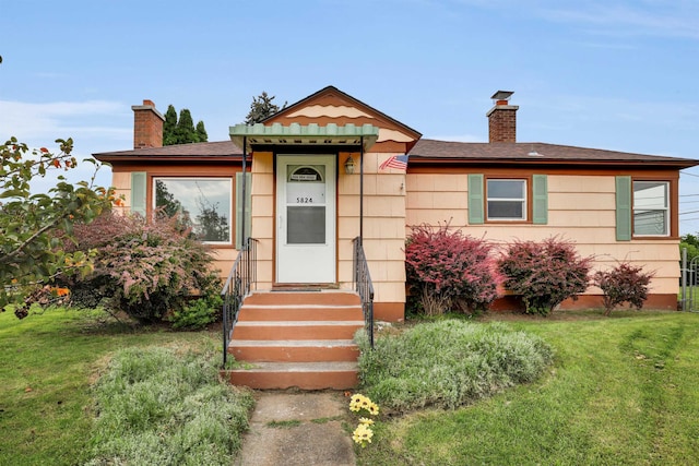 view of front of property featuring a chimney and a front lawn