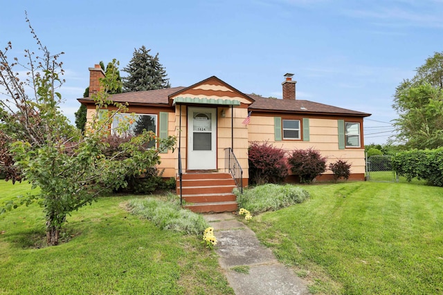 bungalow-style home featuring entry steps, a chimney, a gate, fence, and a front yard