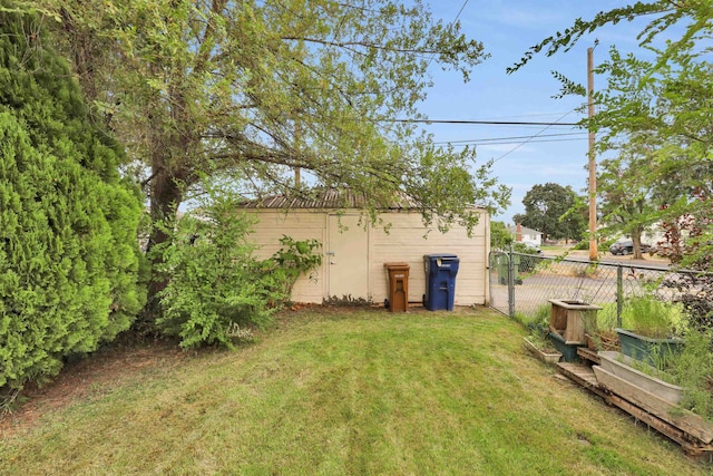 view of yard with an outbuilding, fence, and a gate