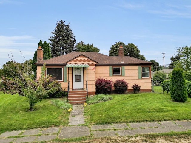 view of front of house featuring a front yard, a gate, fence, and a chimney