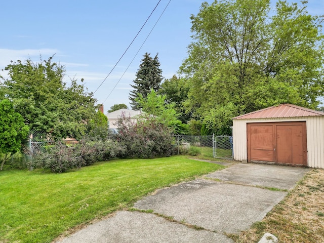 view of yard with an outdoor structure, a gate, fence, and a storage shed