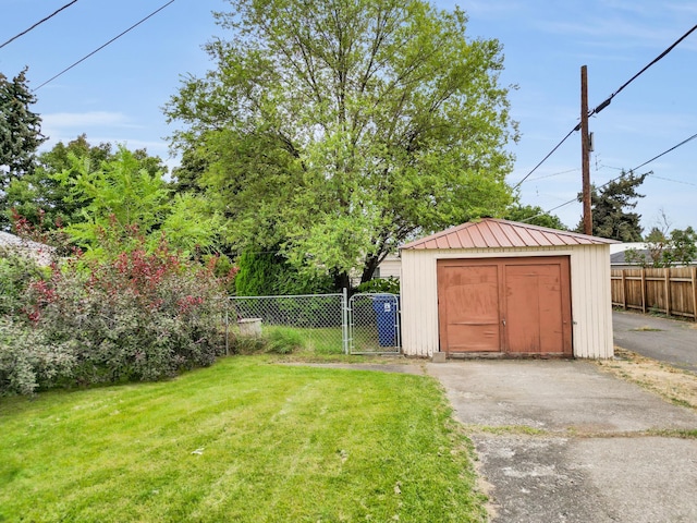 view of yard with a storage shed, an outbuilding, fence, and a gate