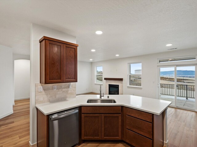 kitchen with decorative backsplash, appliances with stainless steel finishes, white cabinetry, a sink, and light wood-type flooring