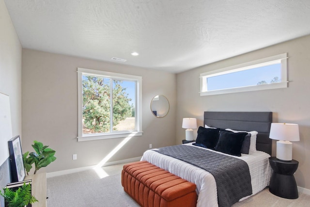 bedroom with carpet floors, baseboards, visible vents, and a textured ceiling