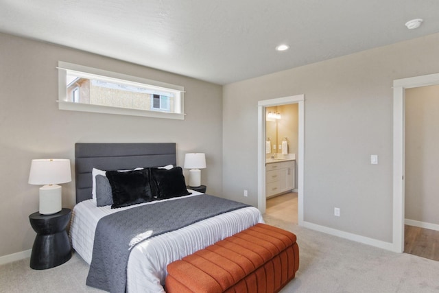 bedroom with recessed lighting, connected bathroom, light colored carpet, and baseboards