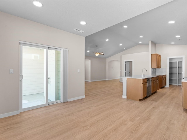 kitchen with open floor plan, light countertops, dishwasher, and light wood finished floors