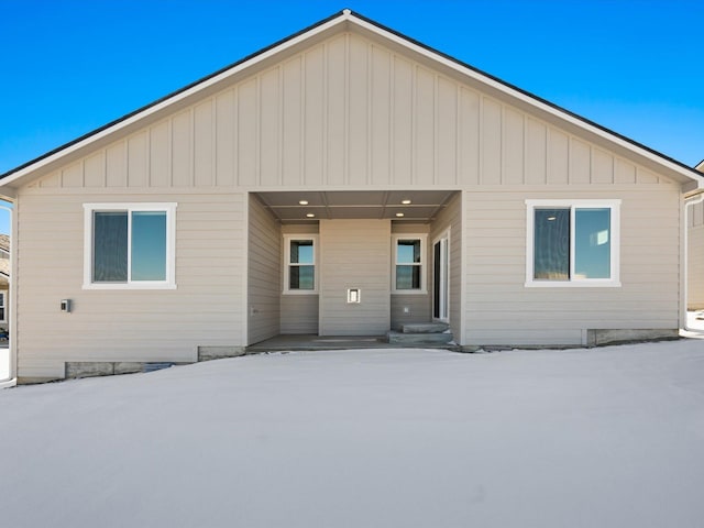 view of snow covered back of property