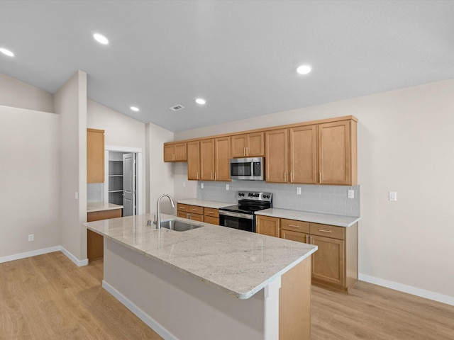 kitchen with light wood finished floors, tasteful backsplash, vaulted ceiling, stainless steel appliances, and a sink