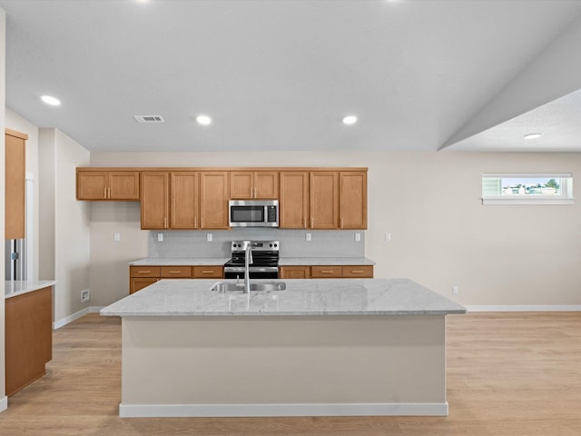 kitchen with visible vents, appliances with stainless steel finishes, brown cabinets, and decorative backsplash