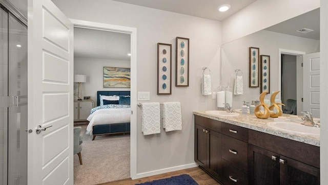 ensuite bathroom with a sink, double vanity, connected bathroom, and visible vents