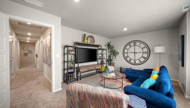 living area featuring a textured ceiling, carpet flooring, and visible vents