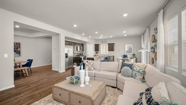 living room featuring baseboards, wood finished floors, and recessed lighting